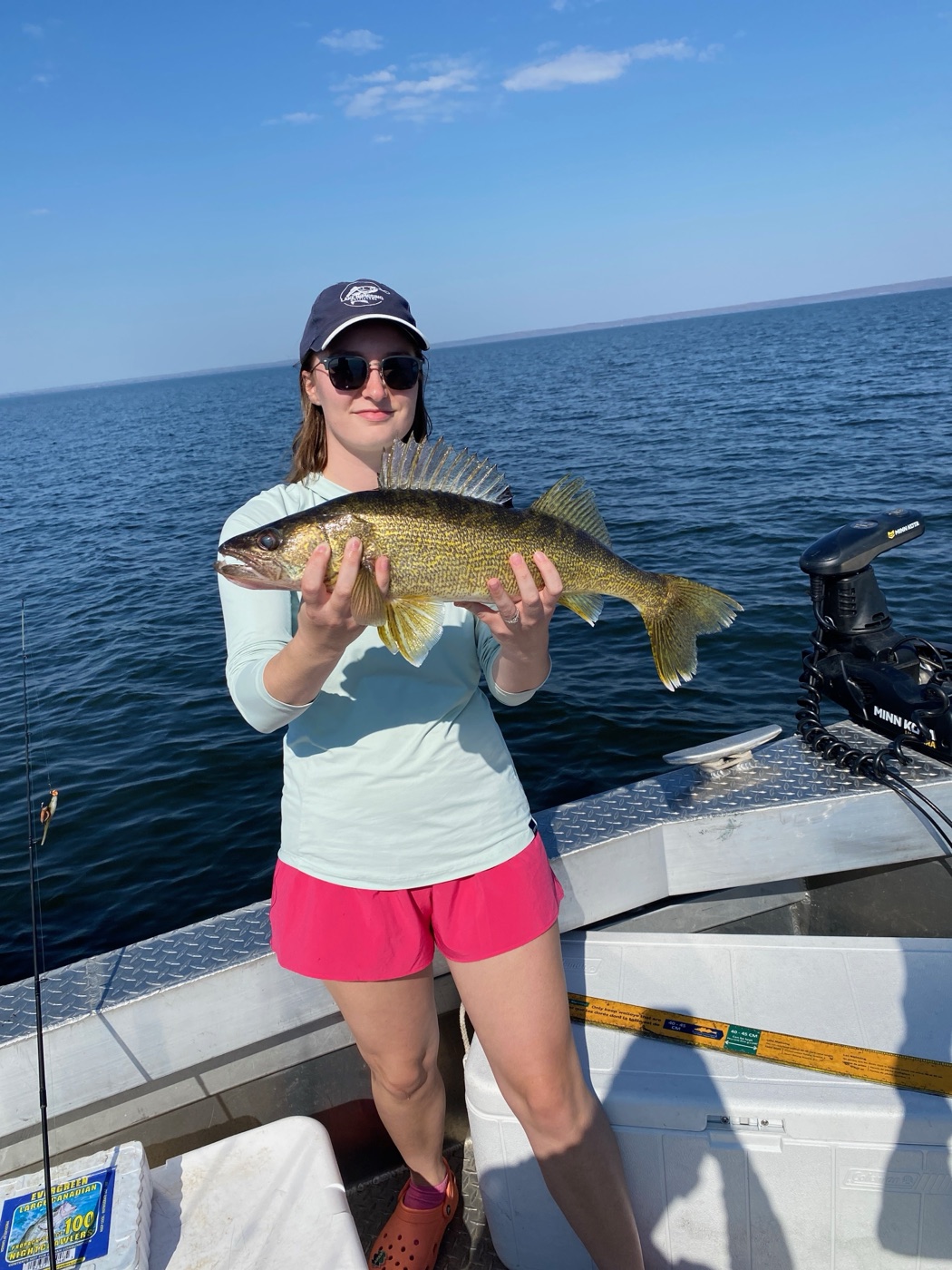 Angler on the boat with fishing rod and walleye on Lake Nipissing